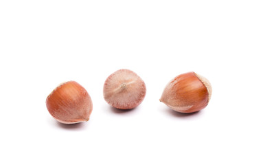 Fototapeta premium Three hazelnuts isolated on white, food background