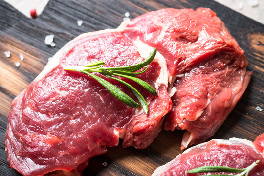 Raw beef steak rib eye with herbs.