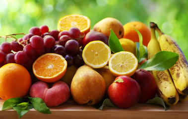 Naklejka na ściany i meble Assortment of ripe fruits on table, green background