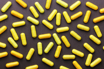 Yellow medicine pills on a grey background