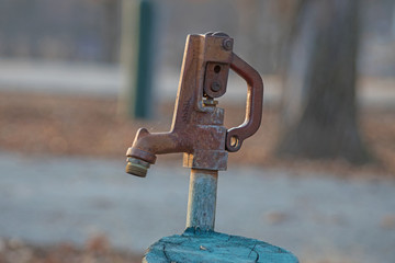 An outdoor faucet at a park. Bokeh background.