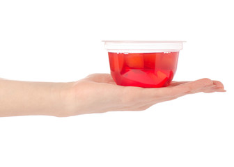 Cup of jelly with fruit red peach in hand isolation