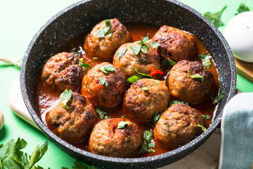 Meat balls in tomato sauce in a frying pan. 