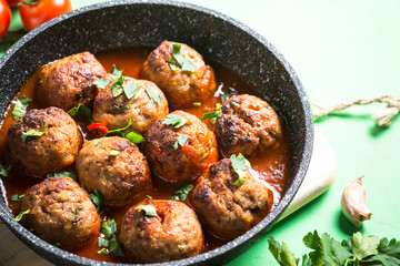 Meat balls in tomato sauce in a frying pan. 