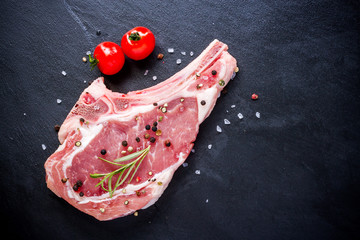 Raw veal cutlet at black slate plate