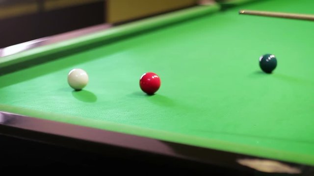 Striking a ball on a snooker table, close-up
