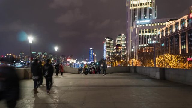 People walk along the embankment of the Vaitan in the evening. The Bund or Waitan is a waterfront area in central Shanghai