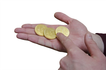 Three gold coins of Bitcoin in hand
