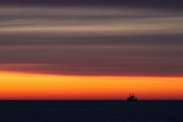 Fototapeta na wymiar Fishing-boat during sunset
