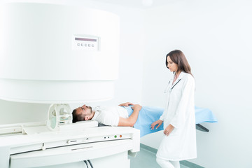 Obraz premium Male Patient In Hospital Bed, getting visited by female doctor to do checkup.