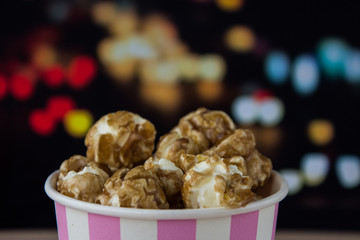 Sweet popcorn on the table. Popcorn in the pink bucket. Snack for the movies. Cinema set. Unhealthy food.