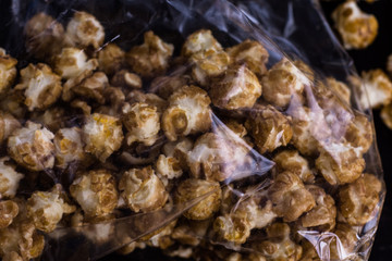 Sweet popcorn on the black background. Popcorn in the pink bucket. Snack for the movies. Cinema set.