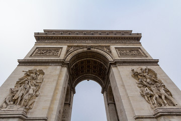 Fototapeta na wymiar Arc de Triomphe (Triumph Arch) on place de l'Etoile in Paris, taken from below. It is one of the most famous monuments in Paris, standing on Champs Elysees on center of Place Charles de Gaulle..