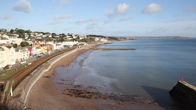 Dawlish Devon train appraoching in English coast town with beach railway train and sea