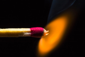 Match on fire on the left side of the corner on a black background