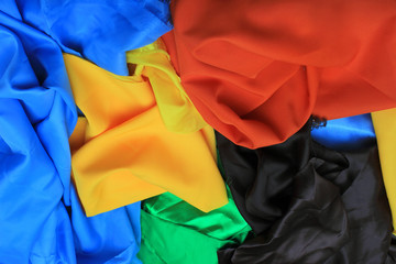 Pile of colorful silk fabrics. Crumpled patches of vibrant colors as background
