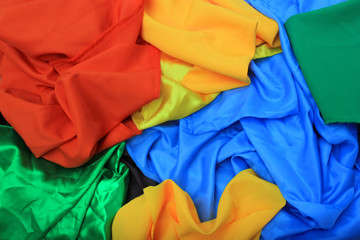 Pile of colorful silk fabrics. Crumpled patches of vibrant colors as background