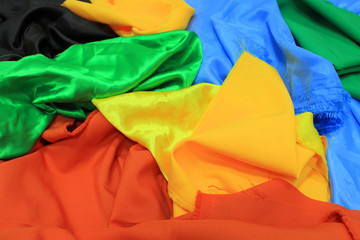 Pile of colorful silk fabrics. Mix of vibrant colors as background