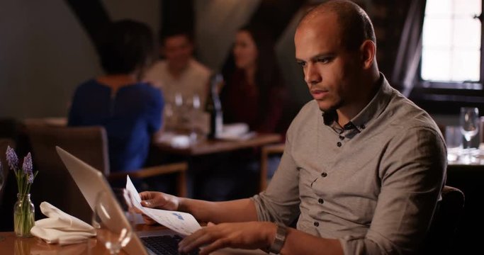 4K Worried restaurant owner working on laptop & looking over the business figures. Slow motion