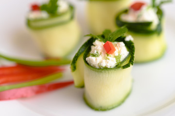 Rolls of zucchini stuffed with cheese and chives and red paprika.