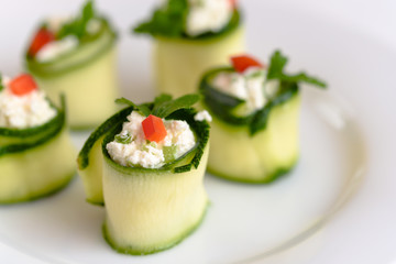 Rolls of zucchini stuffed with cheese and chives and red paprika.