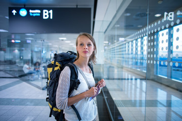 Young female passenger at the airport, waiting for her delayed flight