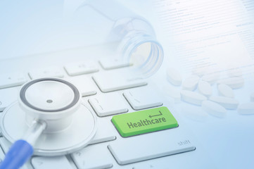 Macro view of a stethoscope on computer keyboard and key botton with healthcare with pill and document background.