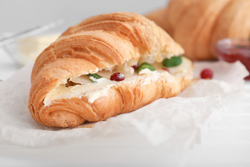 Tasty croissant with filling on table