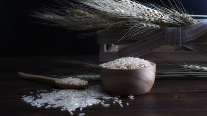 Brown rice and wheat plant on the wooden background