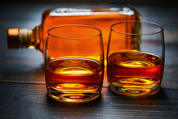 Two glasses with  whiskey on wooden background