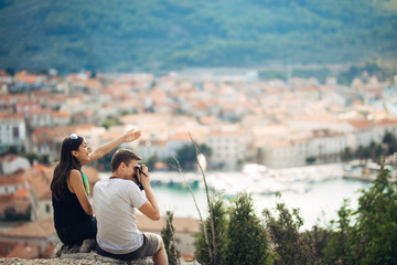 Cheerful young couple having a field trip date.Cityscape sightseeing,seaside travel vacation.Traveling in Europe,visiting Mediterranean road trip.Romantic vacation.Explorer active lifestyle.