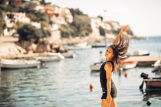 Sensual carefree summer woman enjoying vacation.Seaside stress less lifestyle.Fit traveler enjoying life.Full of energy.Energetic active enthusiastic female.Throwing hair,cheerful sun loving person