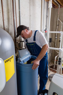 Workman Replacing An Old Domestic Water Softener