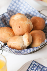 Traditional German Kaiser rolls or Austrian Vienna rolls homemade from yeast dough with white wheat flour in vintage bread basket with blue and white paper napkin on weekend breakfast table
