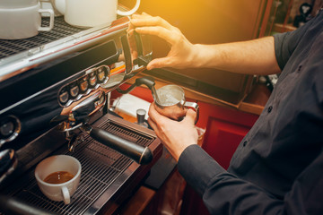 Barista makes coffees in bar. Latte preparation in coffee machine. Hands bartender cooking coffee, preparation milk for latte coffee. Horizontally framed shot.