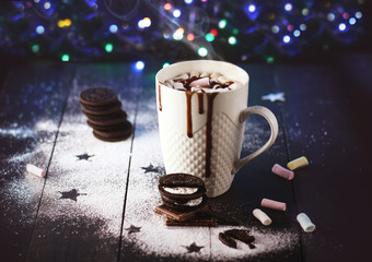 Cup of hot chocolate with marshmallow on a dark wooden background with cookies