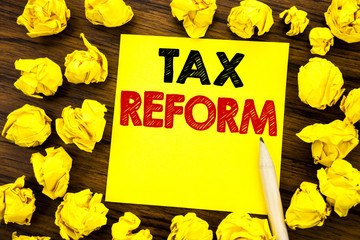 Writing text showing Tax Reform. Business concept for Government Change in Taxes Written on sticky note paper, wooden background with folded yellow paper meaning thinking
