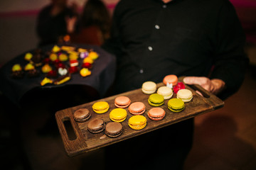 colorful macarons on wooden board. Sweet macaron. Yellow, pink, lime, chocolate