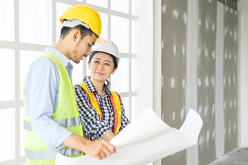 engineers visit the construction site.Examining blueprint with construction manager.