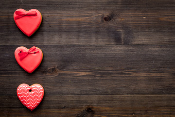 Fototapeta premium St Valentine's Day cookies in shape of heart on dark wooden background top view copy space