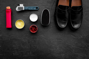Shine shoes. Shoe care with polish, brushes, wax, sponge. Black background top view copy space