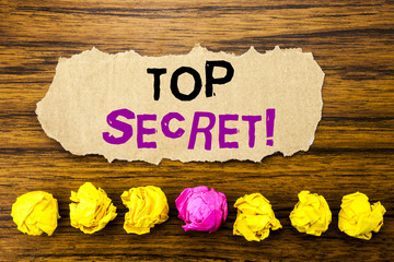 Handwriting text   Top Secret. Concept for Military Top Secret Written on sticky note paper reminder, wooden background with sticky, one folded paper alone for difference or collaboration