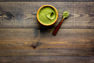 Japanese traditional product. Matcha green tea in bowl on dark wooden background top view copy space