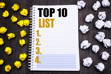 Conceptual hand writing text caption showing Top 10 Ten List. Business concept for Success ten list Written on notepad note notebook book wooden background with sticky folded yellow and white