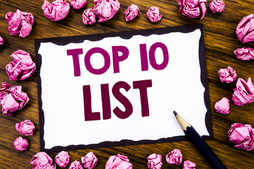 Hand writing text caption inspiration showing Top 10 Ten List. Business concept for Success ten list Written on sticky note paper, wooden background with folded pink paper meaning thinking