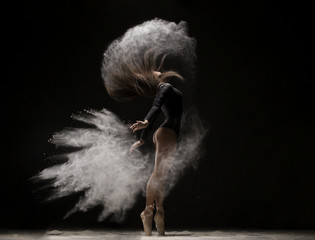 Fototapeta na wymiar Woman in undrewear and pointe shoes in dust cloud