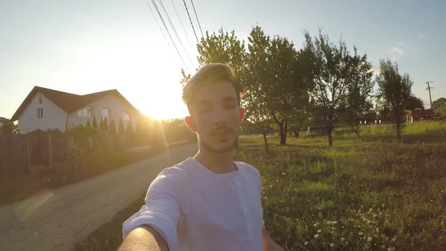 Young male student social media influencer shooting a video outside his house and talking about his experience as popular blogger
