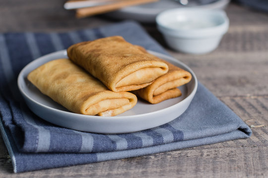 Russian Puncake Crepes stuffed with mushrooms and mozzarella on wooden table background.