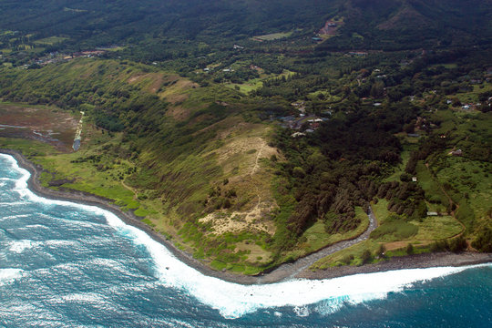 Aerial view of the island of Maui's coastline, waves, and surf in Hawaii, shot from a small, low-flying prop plane