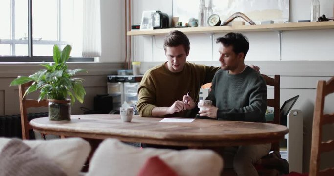 Young male couple signing legal document